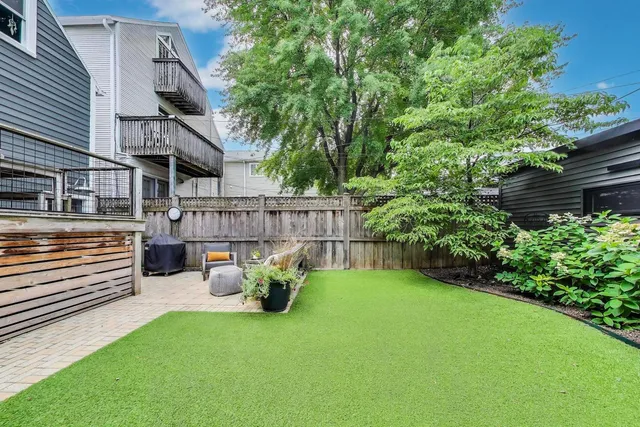 a view of a chair and table in backyard of the house