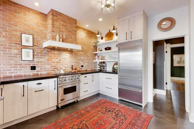 a kitchen with granite countertop a sink stainless steel appliances and cabinets