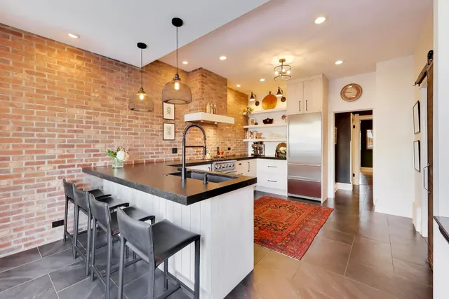 a kitchen with stainless steel appliances kitchen island granite countertop a sink and cabinets