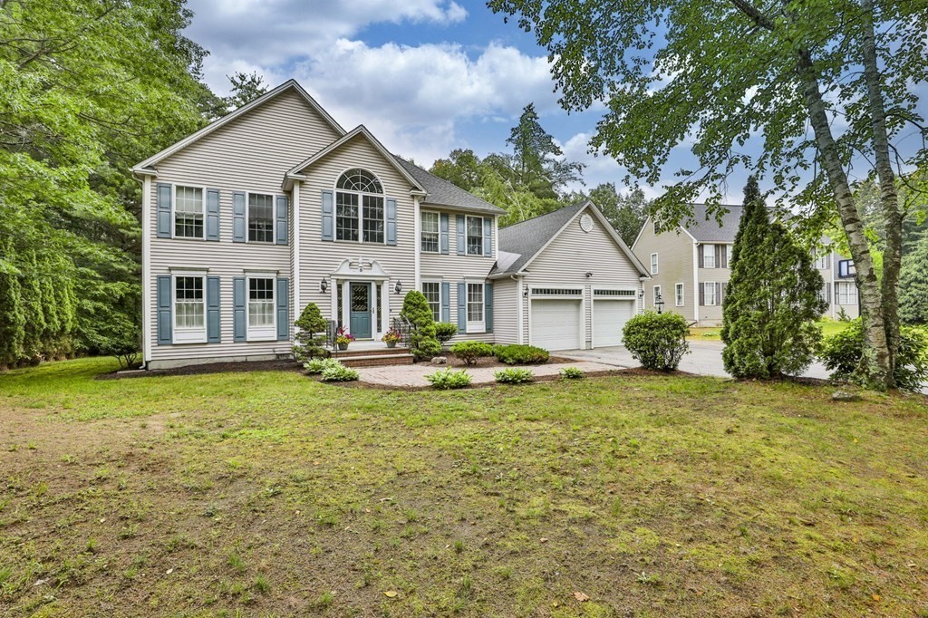 a view of a house with a big yard and large trees