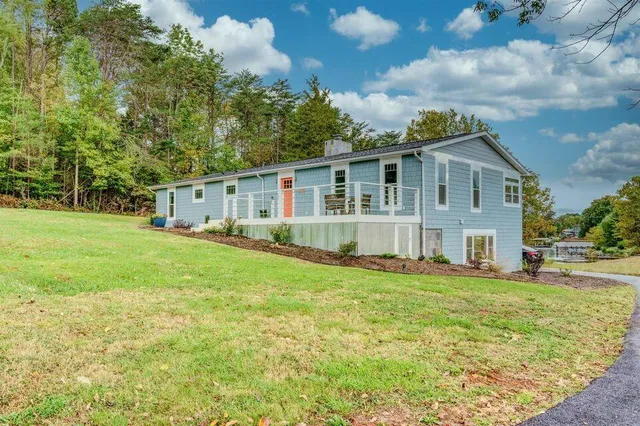 a view of a house with a big yard and large trees