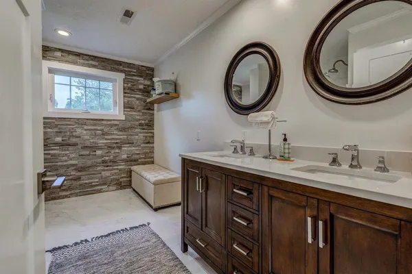 a bathroom with a toilet a double vanity sink and a mirror