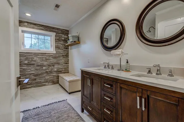 a bathroom with a toilet a double vanity sink and a mirror