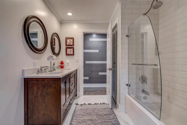 a bathroom with a bathtub a mirror a sink and a shower