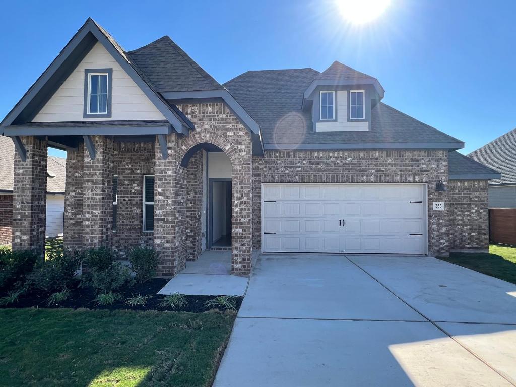 a front view of a house with a yard and trees