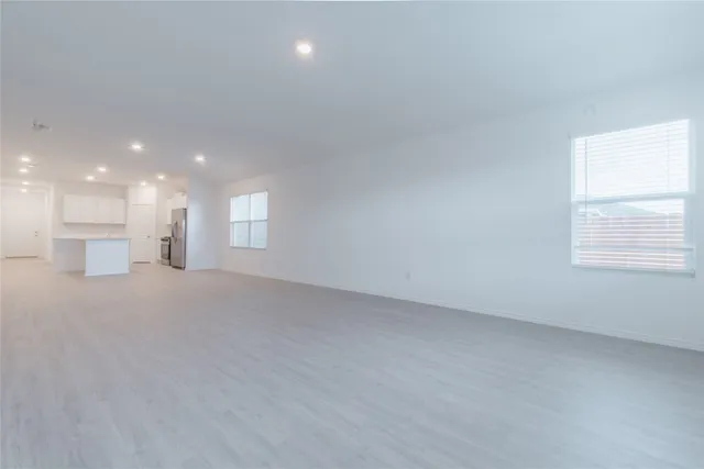 a view of a big room with wooden floor and windows