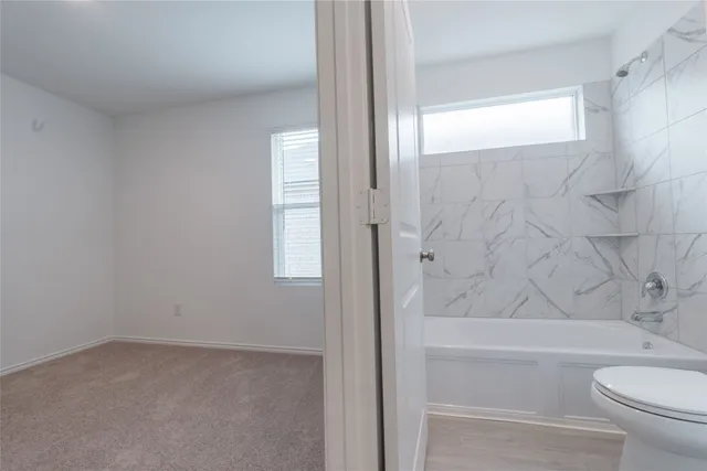 a bathroom with a toilet a sink and mirror