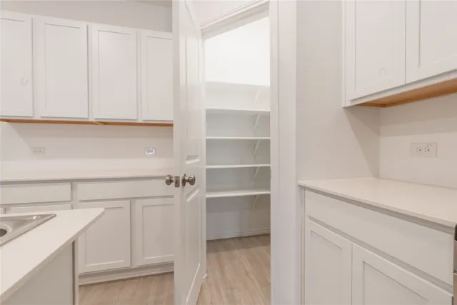 a view of cabinets and utility room with racks on the wall
