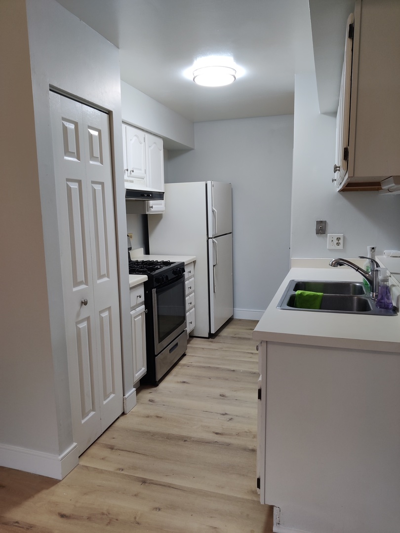2526 Berkshire Court, Unit 2526 Waukegan, IL 60087 - Photo 4 of 16 a kitchen with a refrigerator sink and cabinets