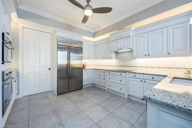 a kitchen with granite countertop a refrigerator oven a sink a washer and dryer