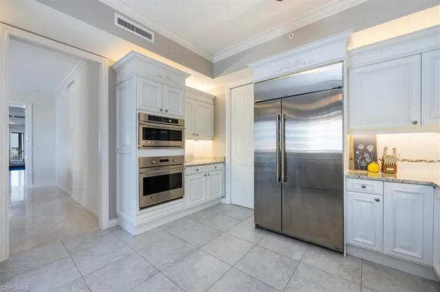 a kitchen with granite countertop a refrigerator and a sink