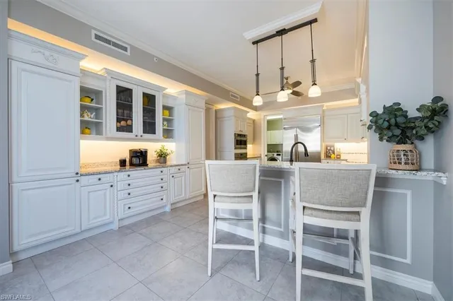 a kitchen with cabinets and chairs