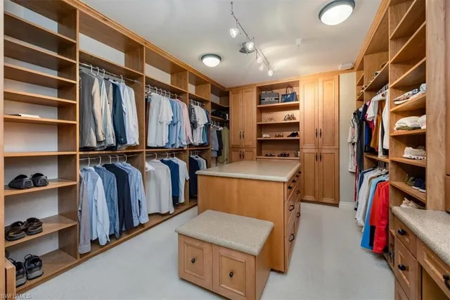 a view of walk in closet with clothes and shoes