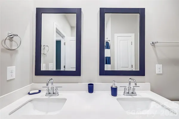 a bathroom with double vanity sinks and a mirror