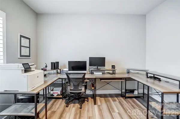 a view of a workspace with furniture and wooden floor