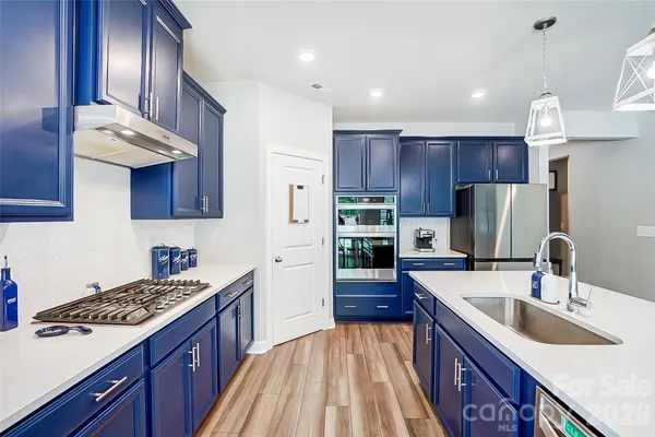 a kitchen with kitchen island granite countertop a sink stove and refrigerator