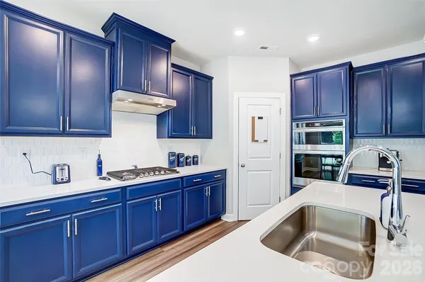a kitchen with a sink a refrigerator and cabinets