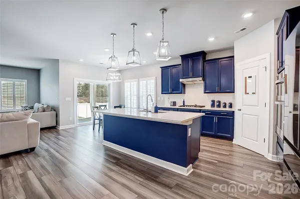 a large kitchen with stainless steel appliances kitchen island granite countertop a large center island attached withe living room