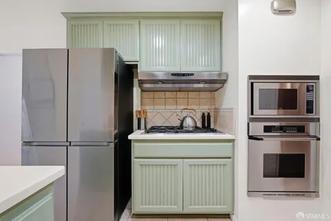 a kitchen with stainless steel appliances a refrigerator and cabinets