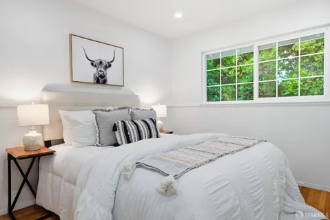 a bedroom with a bed and painting on the wall