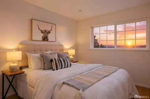 a bedroom with a bed and a painting on the wall