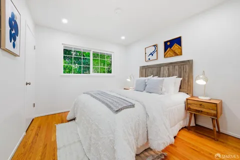 a bedroom with bed and a painting on the wall