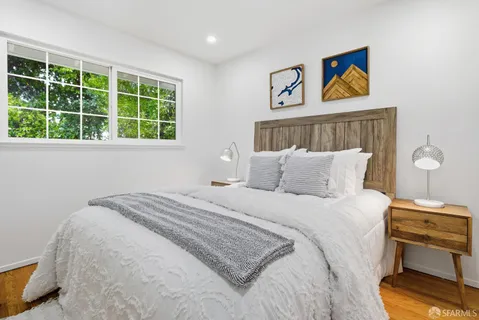 a bedroom with a bed and a painting on the wall