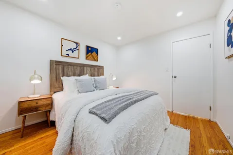 a bedroom with a bed and wooden floor