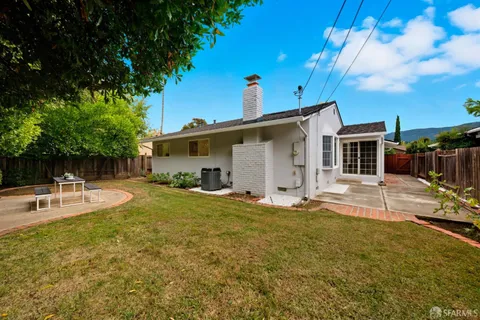 a backyard of a house with table and chairs