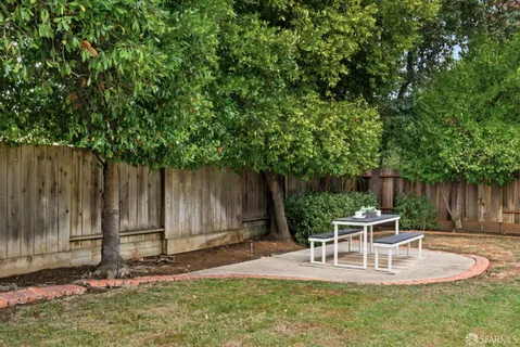 a view of backyard of house with wooden fence