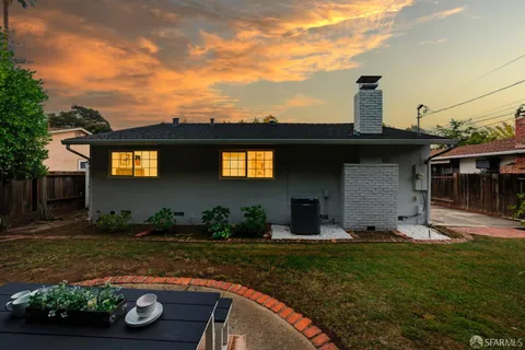 a backyard of a house with table and chairs