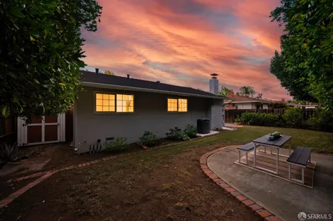 an aerial view of a house with a yard and large tree