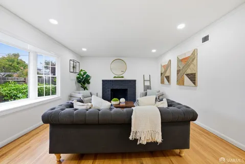 a living room with furniture fireplace and window