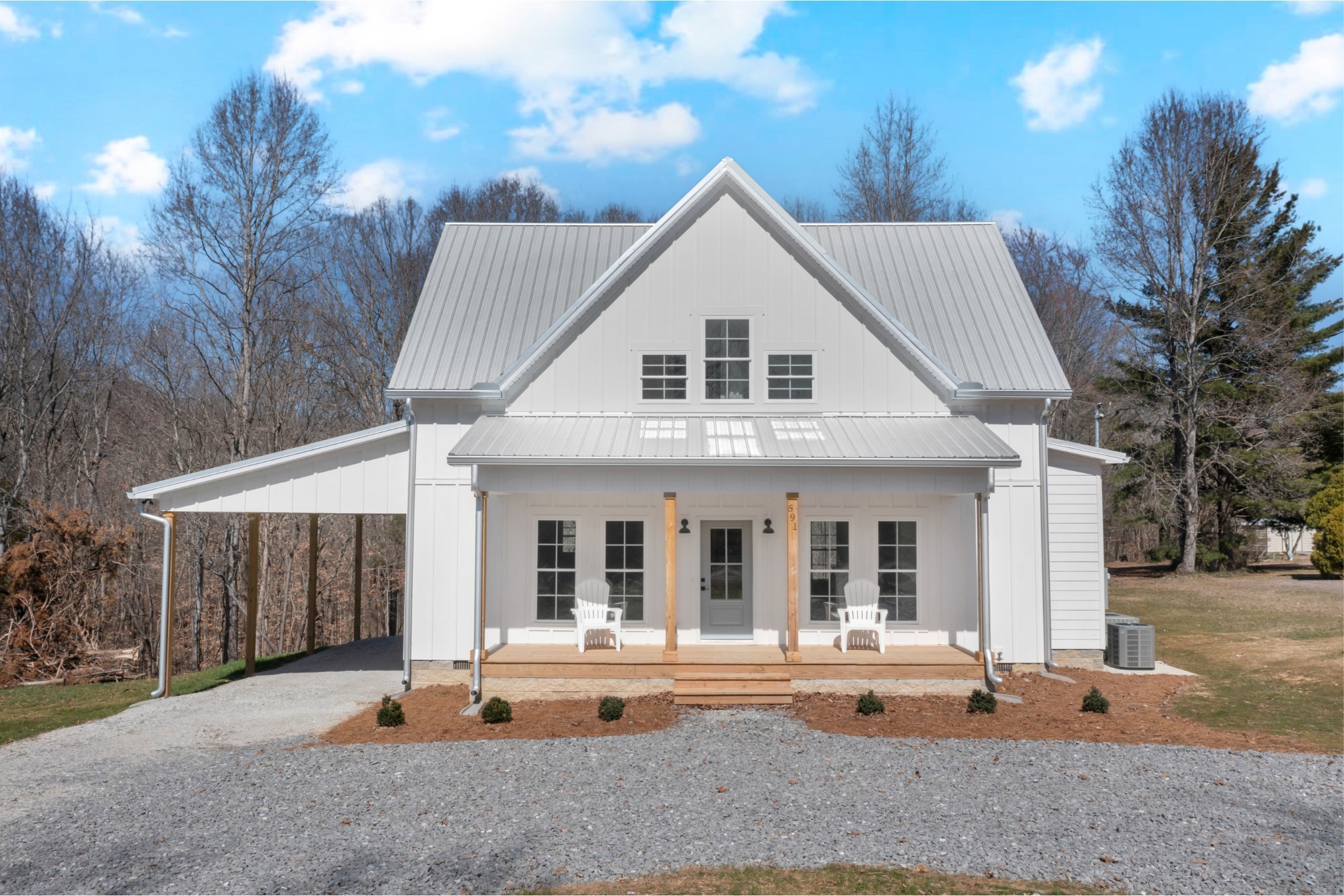 front view of house with a yard and potted plants