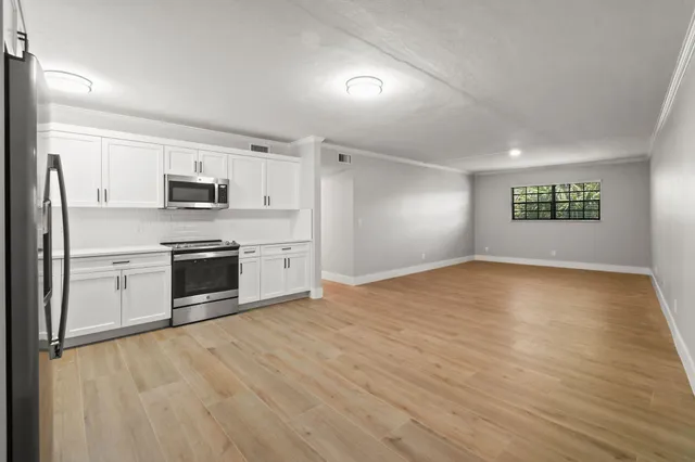 a kitchen with stainless steel appliances a stove top oven a sink and a refrigerator