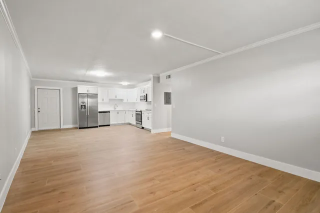a view of empty room with wooden floor