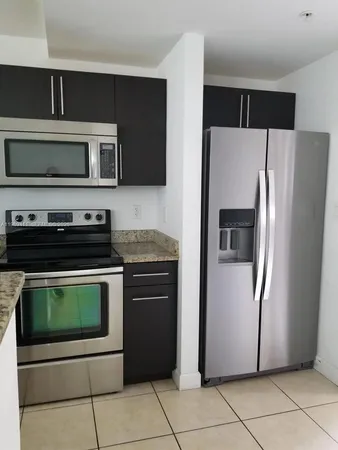 a kitchen with stainless steel appliances granite countertop a refrigerator and a stove top oven