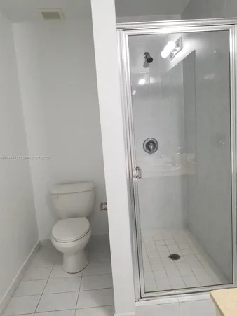 a bathroom with a granite countertop toilet and a shower