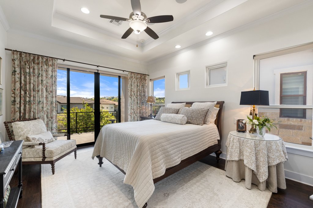 212 Marina View Way, Unit 11A Lakeway, TX 78734 - Photo 12 of 19 a bedroom with a large bed and a chandelier fan