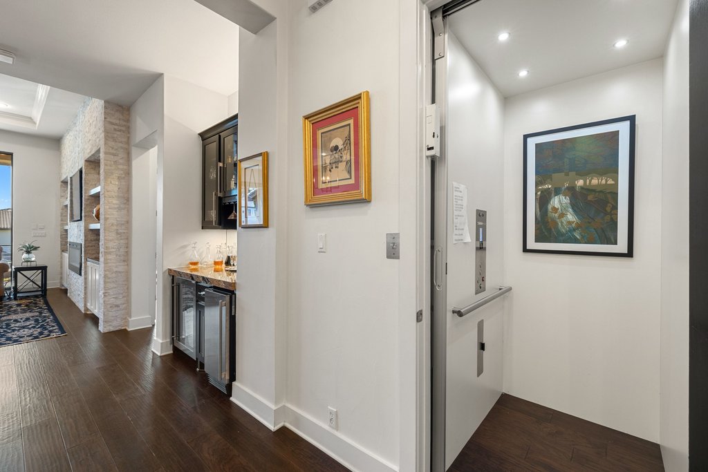 212 Marina View Way, Unit 11A Lakeway, TX 78734 - Photo 10 of 19 a view of a hallway with wooden floor and a flat screen tv