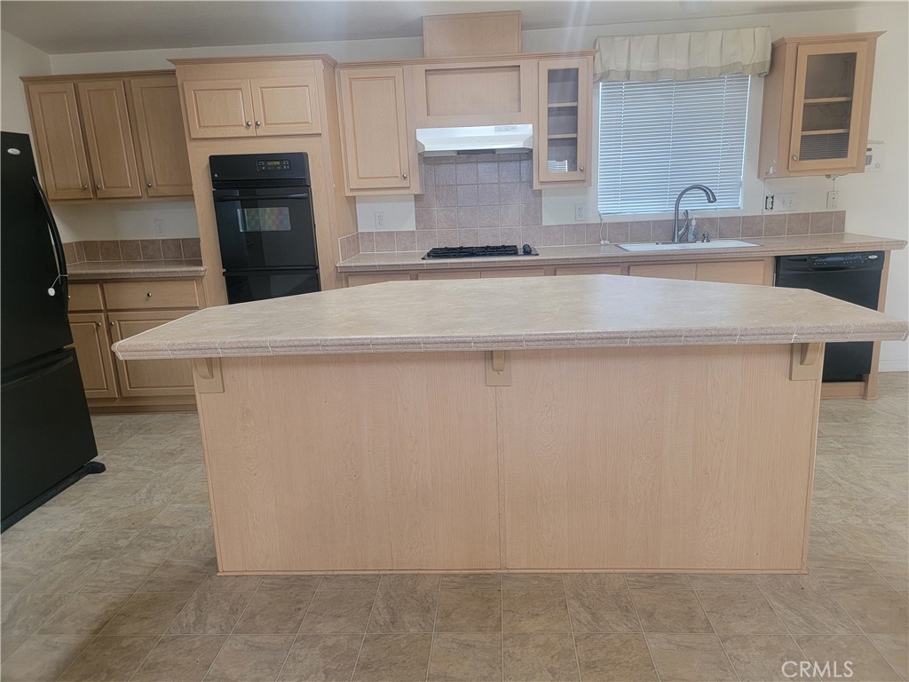 20230 Planada Court Riverside, CA 92508 - Photo 6 of 9 a kitchen with kitchen island a sink a stove and a refrigerator