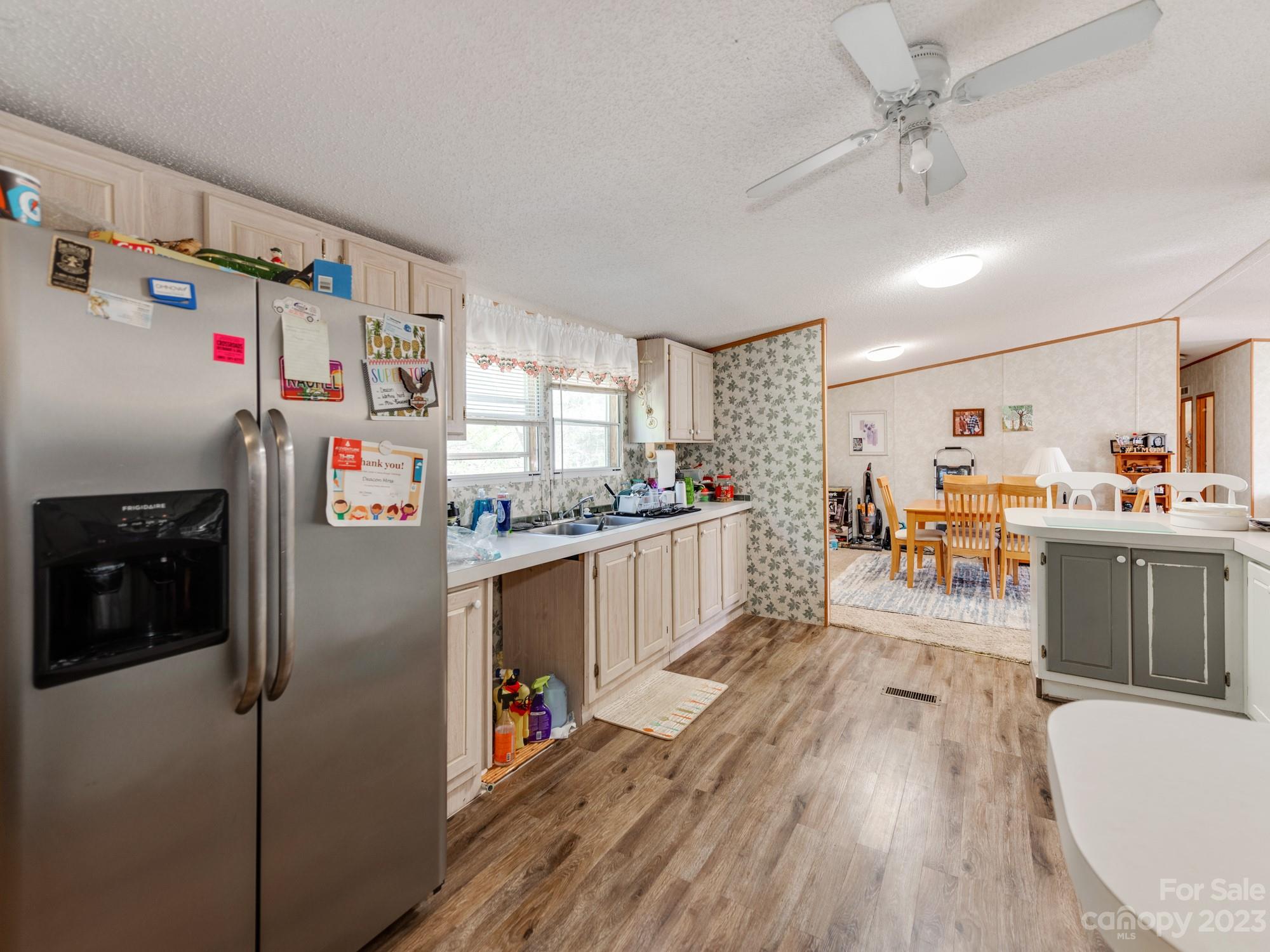 1168 Hopps Road Chester, SC 29706 - Photo 14 of 32 a kitchen with stainless steel appliances a refrigerator a stove a sink dishwasher and a dining table with wooden floor