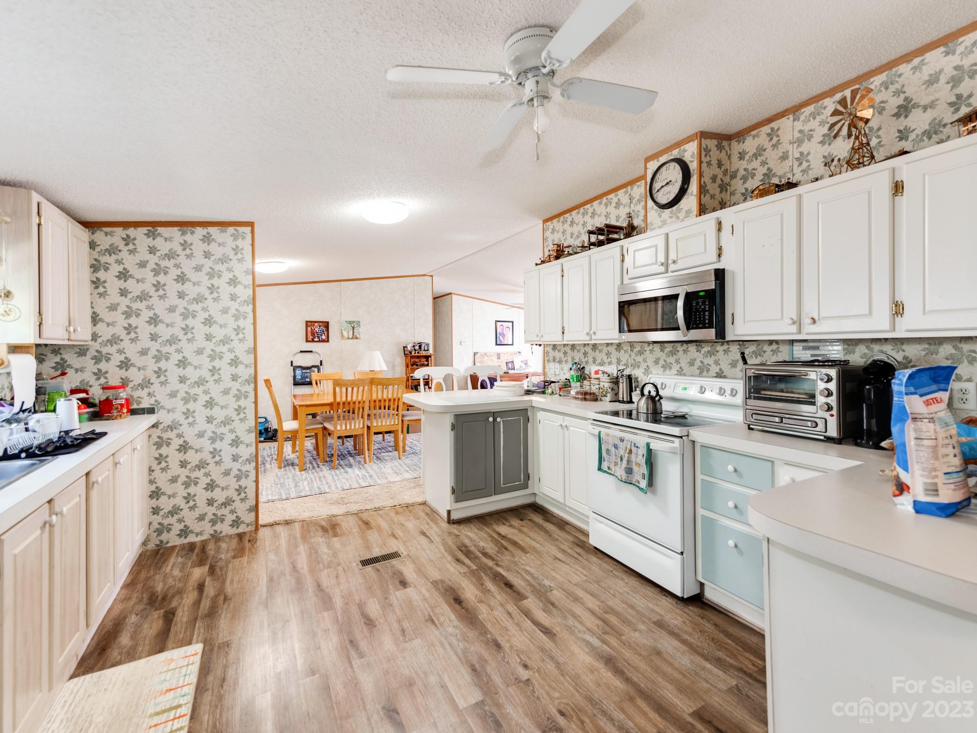 1168 Hopps Road Chester, SC 29706 - Photo 15 of 32 a kitchen with stainless steel appliances granite countertop a refrigerator a stove top oven a sink dishwasher and white cabinets with wooden floor