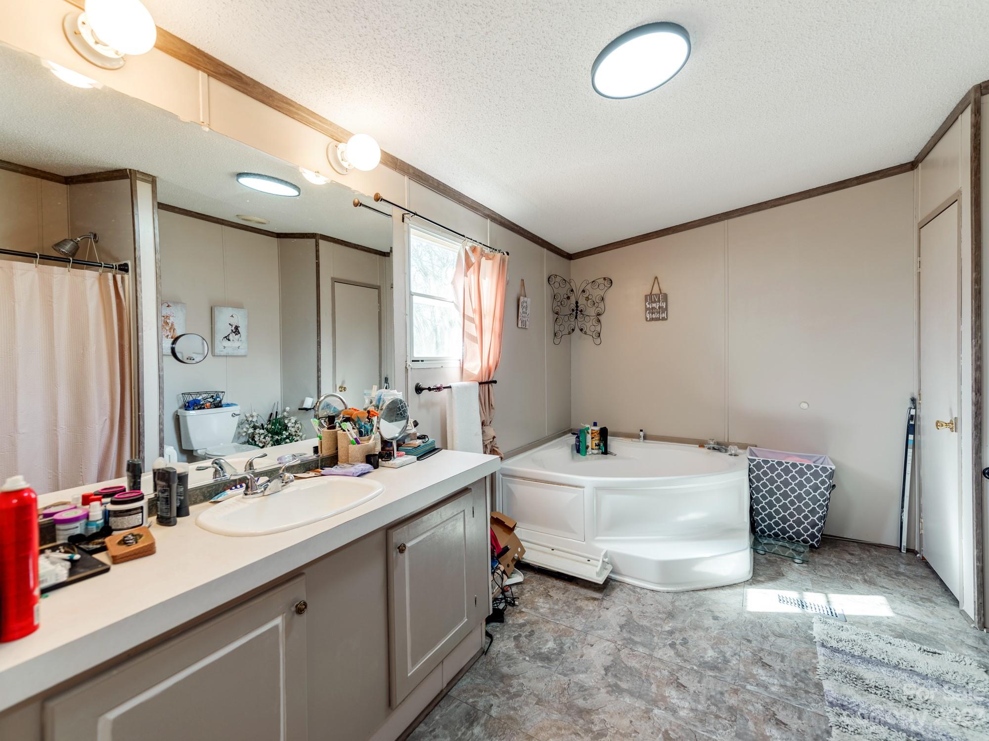 1168 Hopps Road Chester, SC 29706 - Photo 21 of 32 a bathroom with a double vanity sink mirror and bathtub