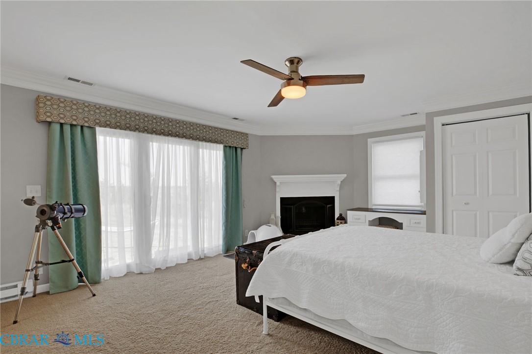 9093 Stump Point Road Hayes, VA 23072 - Photo 20 of 40 Carpeted interior space featuring a white mantel fireplace, a window with a built-in desk, and a ceiling fan with integrated lighting