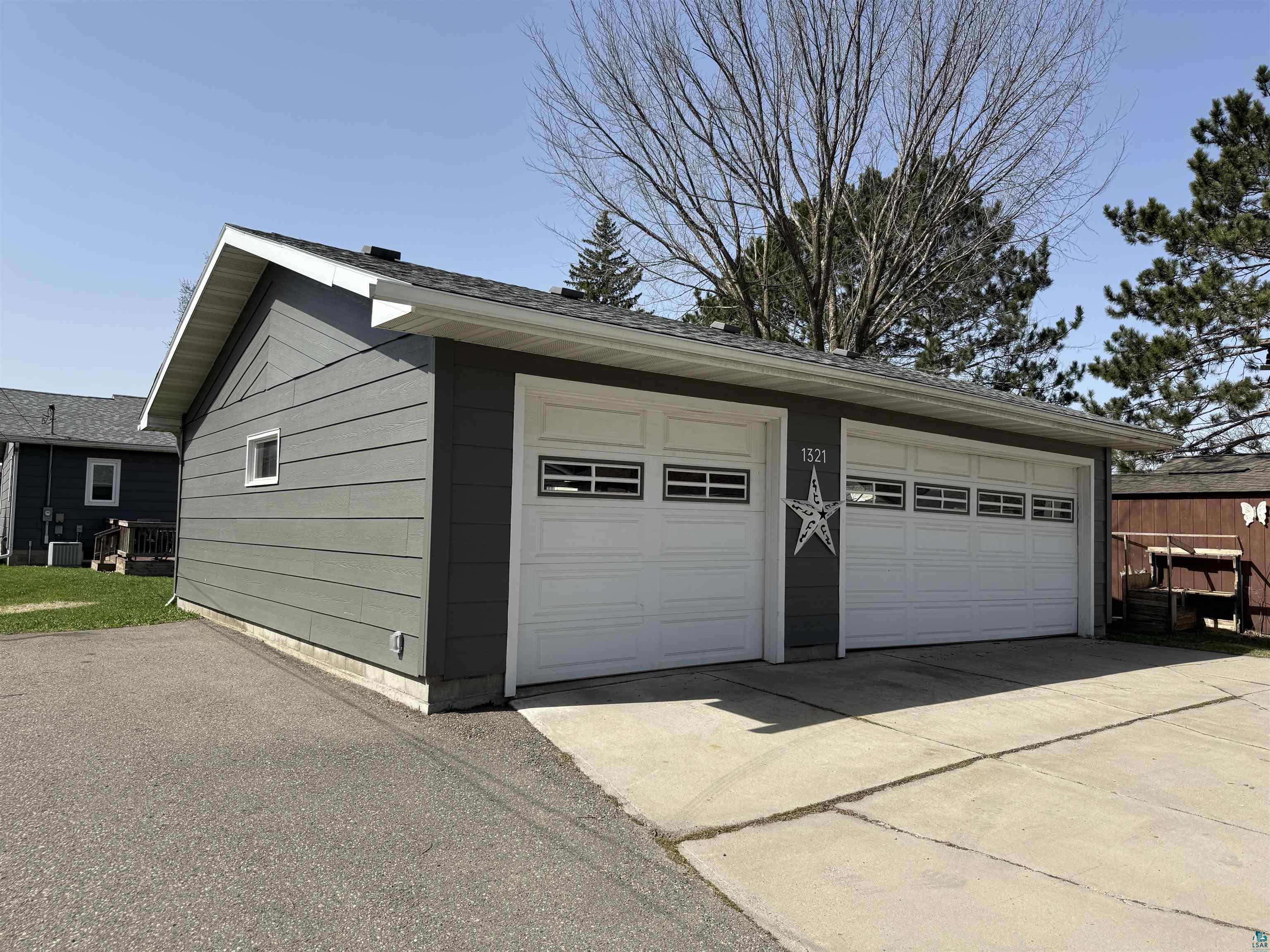 1321 South 13th Street Virginia, MN 55792 - Photo 33 of 33 Detached two-car garage featuring horizontal siding, white overhead doors with window inserts, and concrete driveway apron