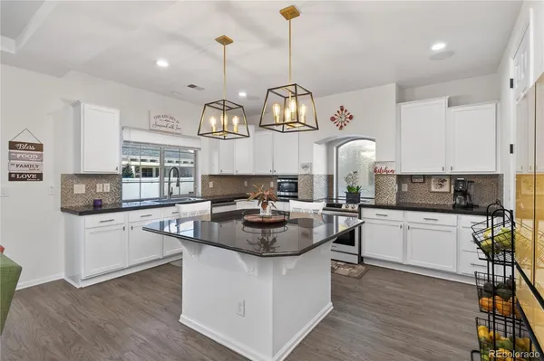 a kitchen with living room and chandelier