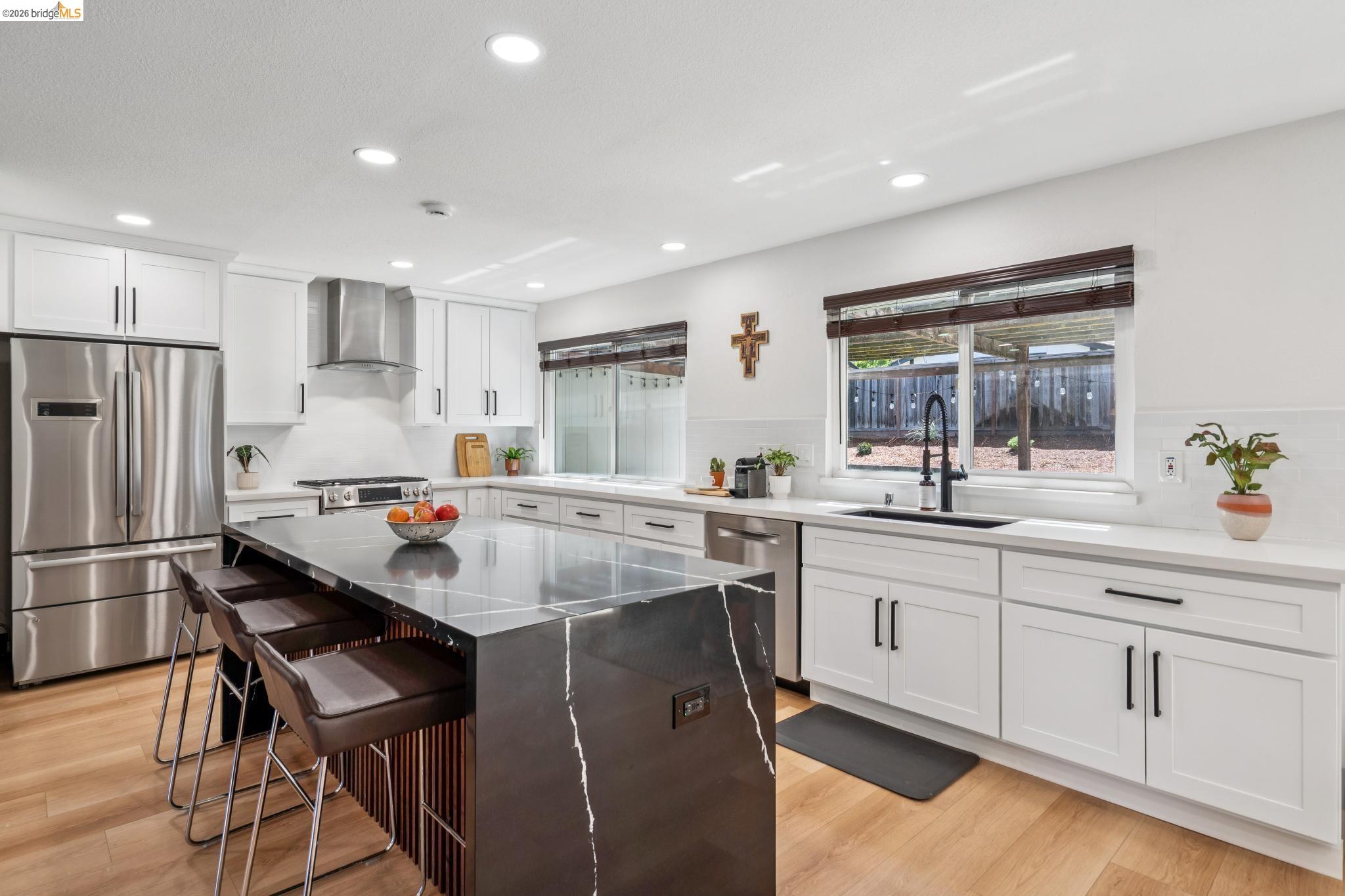 3093 Diablo View Road Pleasant Hill, CA 94523 - Photo 12 of 43 Kitchen with appliances with stainless steel finishes, a kitchen bar, dark stone counters, recessed lighting, and white cabinetry