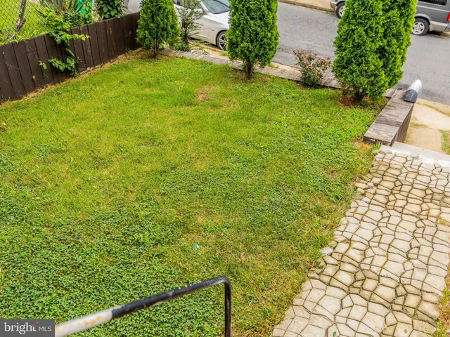 a view of backyard with plants and wooden fence