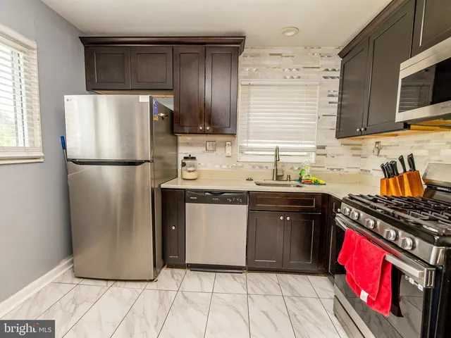 a kitchen with stainless steel appliances granite countertop a refrigerator stove top oven and sink